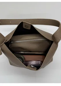 Vista superior del amplio compartimento interior del bolso baguette de cuero gris