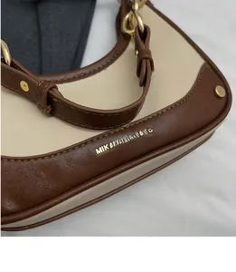 Macro detail of crescent bag with lychee texture leather and gold metal buckle