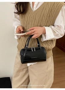 Détail du sac Boston en cuir ciré noir avec fermetures éclair et logo MUHETI