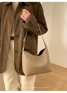 Primer plano detallado del bolso hobo de cuero granulado beige llevado al hombro