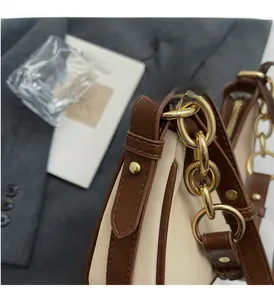 Detailed close-up of golden chain hardware and premium leather trim on a stylish cream bag