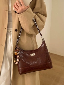 Dark brown quilted leather bucket bag with chain strap and star pendant for office wear