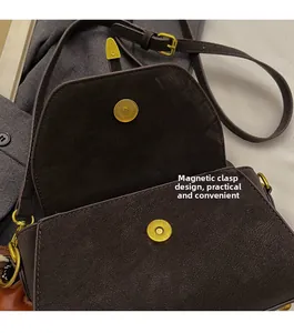 Detalle del bolso bandolera marrón vintage con cierre magnético y herrajes dorados