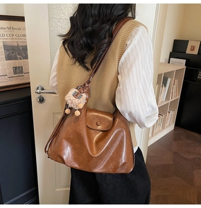 Brown vintage faux leather tote bag detail with magnetic flap and cute plush lamb charm