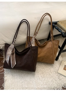 Detail view of vintage tote bags in coffee and camel with decorative printed scarves