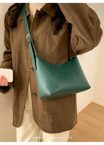 Modelo con bolso hobo de cuero granulado verde oscuro y correa ajustable de calidad