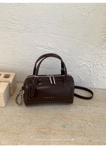 Vue détaillée du sac polochon en cuir marron avec zips argentés et détails de chaîne