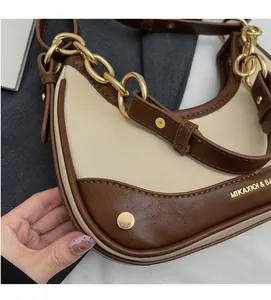 Detail of retro color-block crescent bag with gold chain and premium leather texture