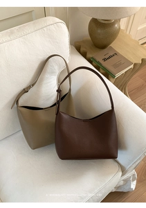 Detalle de bolsos de media luna minimalistas en café y caqui con textura de cuero