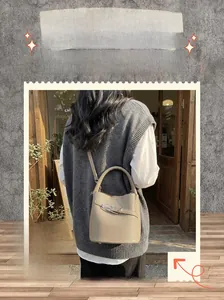 Detail of grey bucket bag with pebble leather texture and elegant silver metal buckle