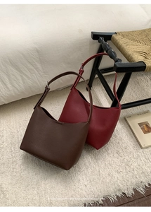 Primer plano de bolsos hobo minimalistas de cuero granulado en marrón y rojo retro