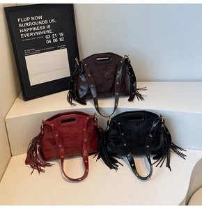 Detailed view of three crocodile pattern tote bags with long tassels and eyelet straps