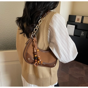 Close-up of hobo shoulder bag featuring color-block leather and ethnic beaded tassel