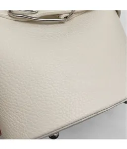 Close-up of white lychee grain leather handbag with silver hardware and fine stitching