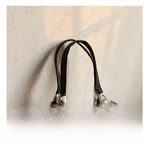 Detail of plush leopard print tote bag featuring durable dark brown shoulder handles