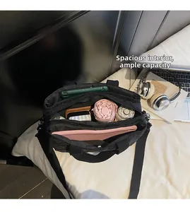 Top view of spacious interior of black quilted tote bag holding a tablet and daily items
