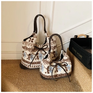 Detailed comparison of large and small knit tote bags with snowflake patterns and leather handles