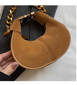 Vue détaillée du mini sac en cuir marron avec texture et chaîne dorée élégante