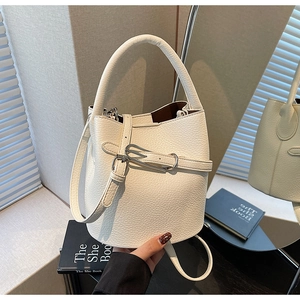 Detail of white litchi pattern leather bucket bag with metal buckle and soft lining