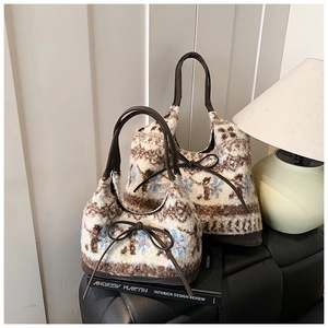 Detail of plush knit tote bag set with snowflake pattern and brown leather handles