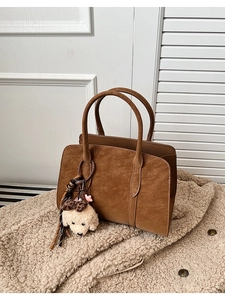 Gros plan du sac cabas en cuir marron vintage avec un joli porte-clés chien en peluche