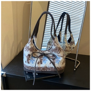 Detail of floral plush tote bag with brown ribbon bow and faux shearling texture