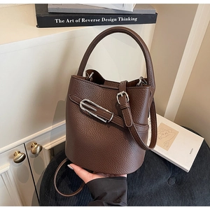 Detail of premium brown pebble leather bucket bag with silver buckle and crossbody strap