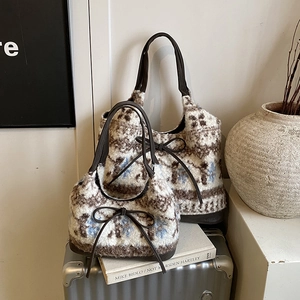 Detail of plush tote bags with Fair Isle patterns and brown leather handles on luggage