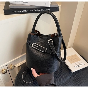 Detail of black lychee grain leather bucket bag with silver hardware and dual straps