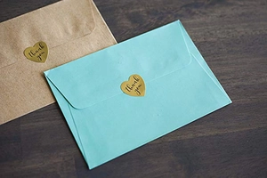 Detail of 1 inch gold heart Thank You stickers used for sealing gift envelopes