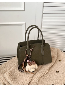 Détail du sac cabas en cuir mat vert foncé avec charmant pendentif chien en peluche