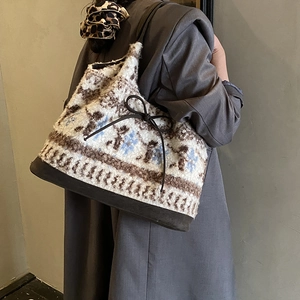 Detail of Nordic snowflake pattern on plush tote bag with brown leather bottom