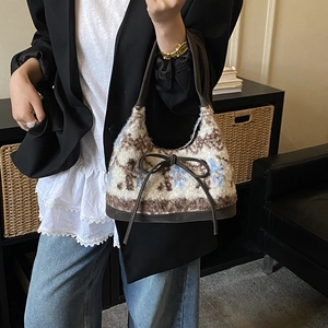 Detail of floral plush hobo bag with brown leather trim and bow tie detail
