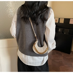 Detail of cream crescent bag with gold chain strap and smooth matte leather texture