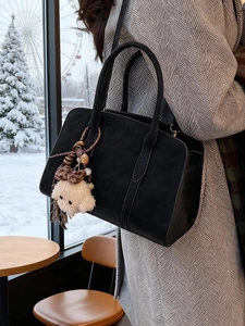 Sac fourre-tout noir vintage avec breloque en peluche dans un décor d'hiver