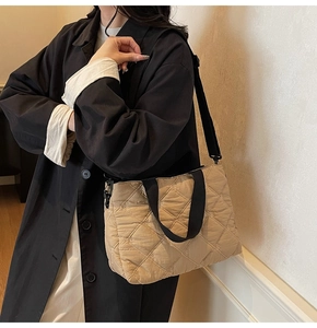 Detailed shot of khaki quilted tote bag with black wide strap and diamond stitch texture