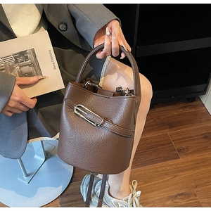 Detailed shot of dark brown lychee grain leather bucket bag with silver buckle accent