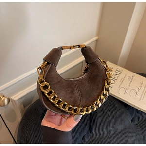 Detail of dark brown suede hobo bag featuring gold chain link and metallic buckle clasp