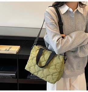 Detail of green quilted tote bag with diamond stitching and adjustable shoulder strap