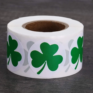 Roll of white circular St. Patrick's Day stickers featuring green shamrock patterns
