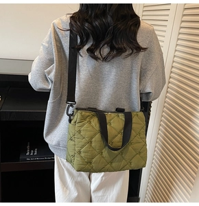 Close-up of olive green quilted tote bag with embroidered bows and black strap