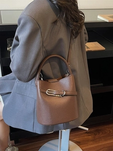 Brown leather bucket bag with metal buckle detail and top handle for women