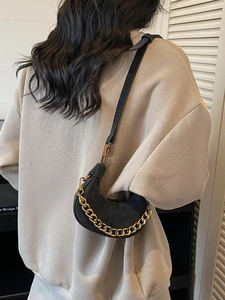 Elegant black hobo bag with a stylish gold chain strap and sleek leather finish