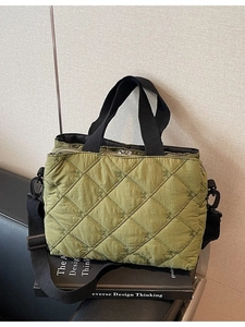 Quilted green crossbody bag with bow embroidery and adjustable black shoulder strap