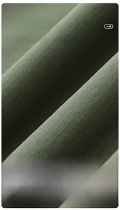 Macro shot of army green ripstop fabric texture showing high-strength grid weave details