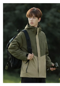 Details einer Outdoor-Kapuzenjacke in Armeegrün und Khaki mit praktischer Reißverschlusstasche