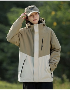 Detail der winddichten Kapuzenjacke in Khaki und Beige mit Kordelzug und Farbfeldern