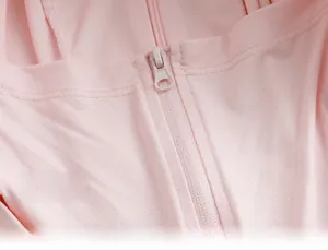 Macro shot of breathable micro-hole fabric and matching zipper on pink sun protection jacket