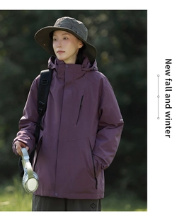 Detail der lila wasserdichten Jacke mit Kapuze und grünem Sonnenhut für Outdoor-Wandern