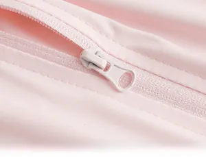 Detail of pink functional fabric with smooth zipper and circular ring puller on the jacket